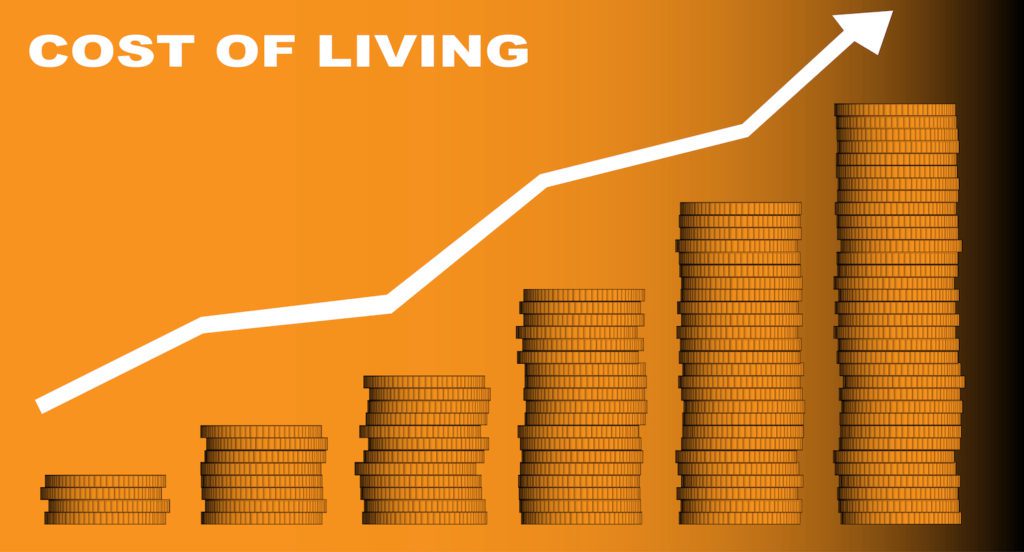 A stack of coins and an arrow pointing upwards with the legend cost of living in white.