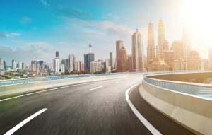 road with curve ahead and city in background