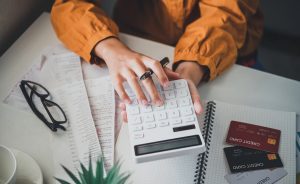 business person sitting at a desk at an office By using the calculator to work. Business Concept Analysis and Planning