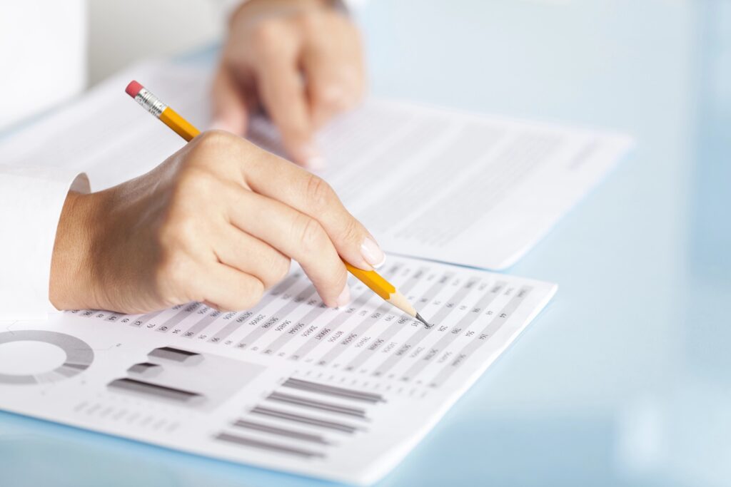 Close-up of a businesswoman's hand with a pencil writing something.